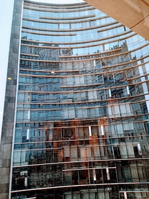 A modern glass building with a curved facade and horizontal lines.