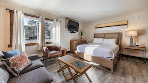 Une chambre d’hôtel équipée d’un lit, d’une télévision, d’un bureau, d’une chaise, d’une table basse et d’un canapé.