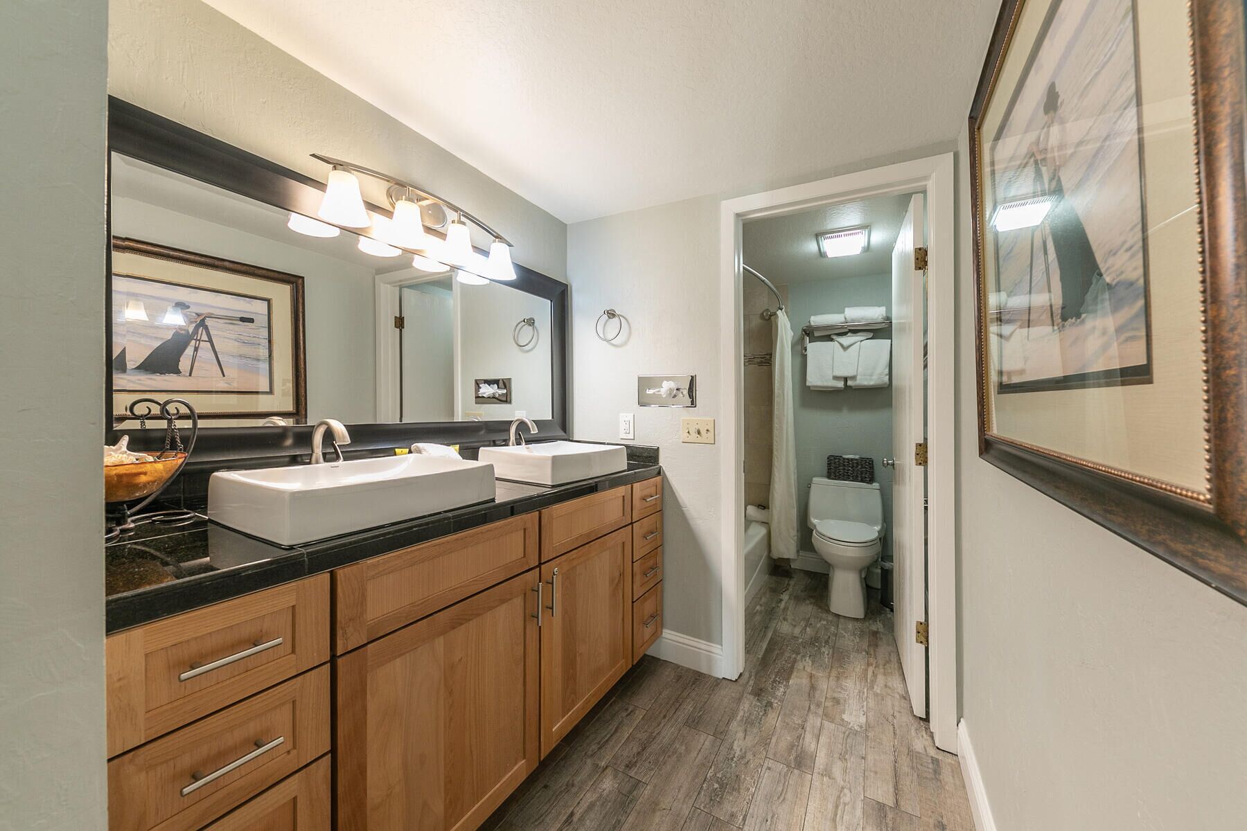 A modern bathroom with a double sink vanity, a large mirror, and a shower area.