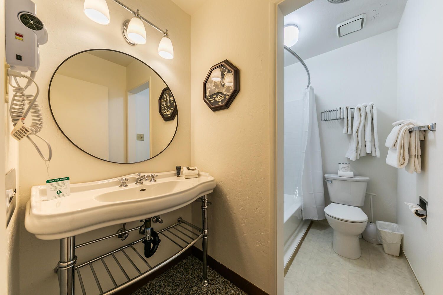 A bathroom with a white sink, mirror, and towel rack.