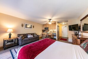 Une chambre d’hôtel comprenant un lit, un canapé, une table à manger et un coin cuisine.