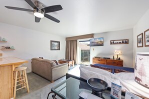 Une chambre d’hôtel comprenant un lit, un canapé, une table à manger, un ventilateur de plafond et une vue sur l’extérieur.
