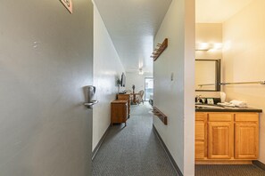 A hallway with a wooden cabinet, a coat rack, and a ceiling fan.
