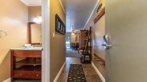 A hallway with a bathroom on the left, a dining area in the center, and a door with a keypad lock on the right. - Cozy Deluxe Studio #131 at Donner Lake Village (Truckee)