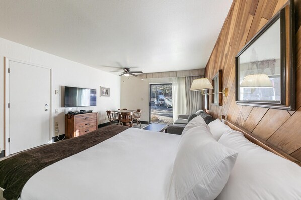 Ein Hotelzimmer mit Bett, Schreibtisch, Fernseher und Blick nach draußen.
