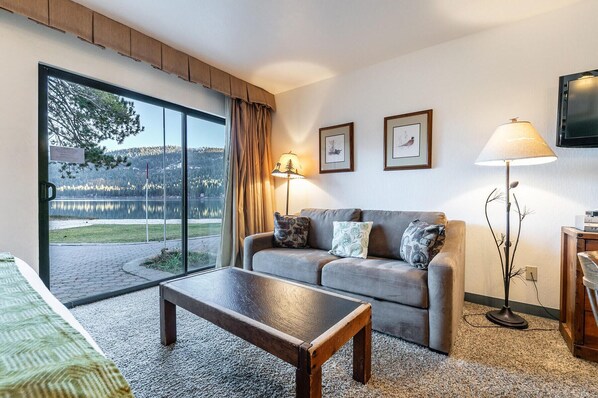 A living room with a sofa, a coffee table, a lamp, and a TV.