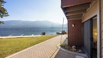 A pathway leading to a building with a view of a lake and mountains.