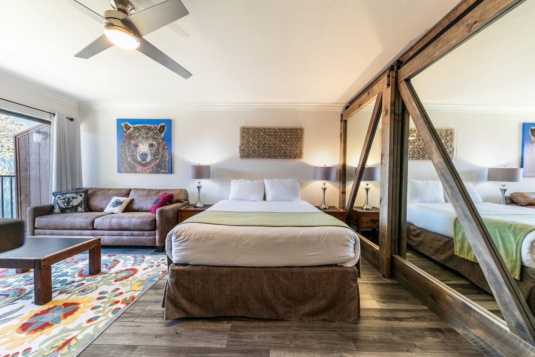Un dormitorio amplio con una cama grande, un sofá y un ventilador de techo.