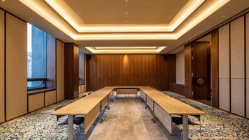 A conference room with a long table, carpeted floor, and wooden panel walls.