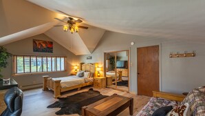 A cozy bedroom with a sloped ceiling, a bed, a desk, and a mirror. - Come ride the newly opened Argo Mine Gondola and stay ahead of the traffic. (Idaho Springs)