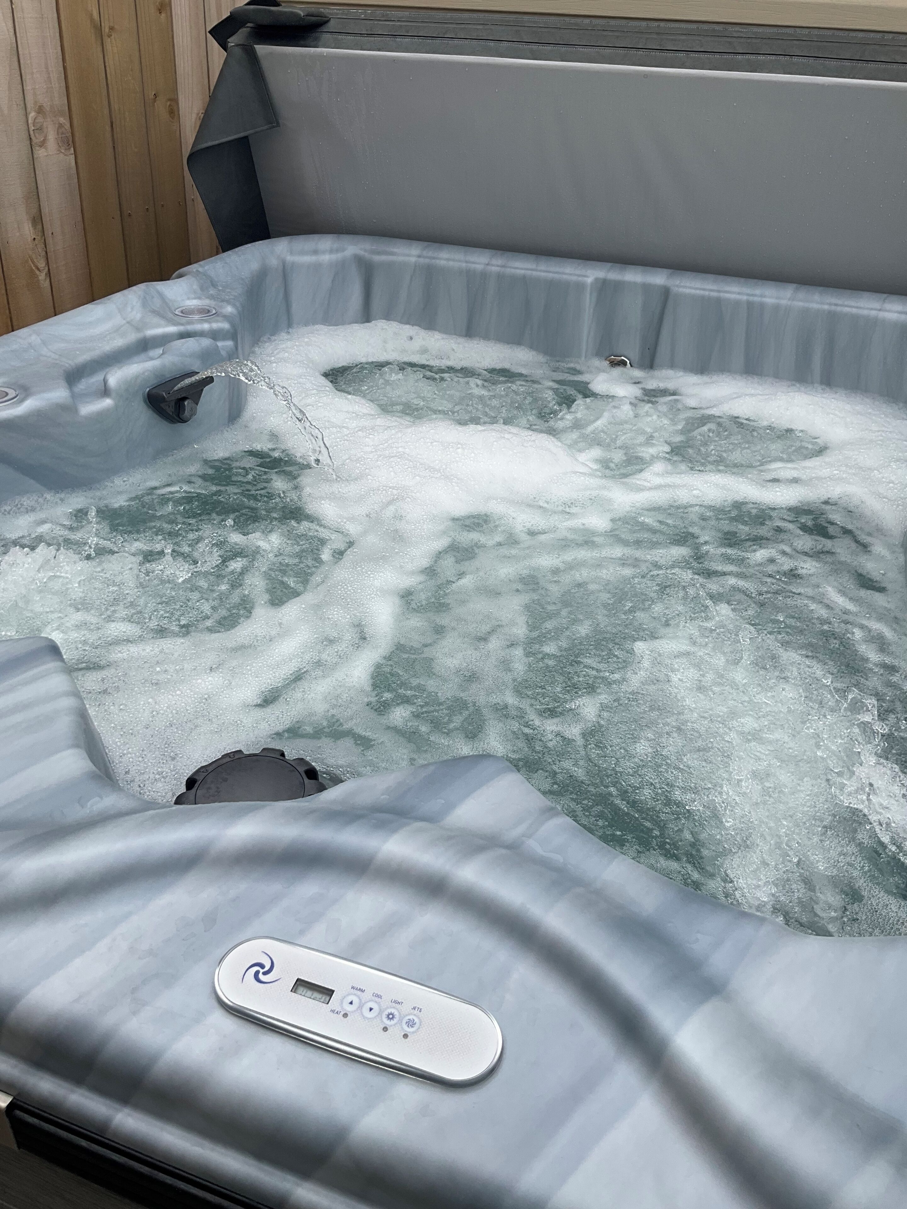 Un bain à remous équipé d’un panneau de commande et d’une pompe à eau.