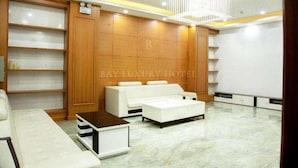 A modern hotel lobby with a white sofa, a coffee table, and a chandelier. - Hana Hotel by Bay Luxury (Hanoi)