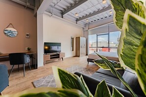 A modern living room with a TV, sofa, and large windows. - VH | Great Location @Roma. Designed Loft | 313 (Ciudad de México)