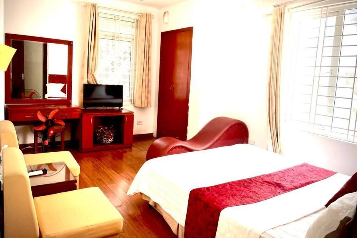 Ein Hotelzimmer mit Bett, Schreibtisch mit Fernseher, Stuhl und Kleiderschrank.