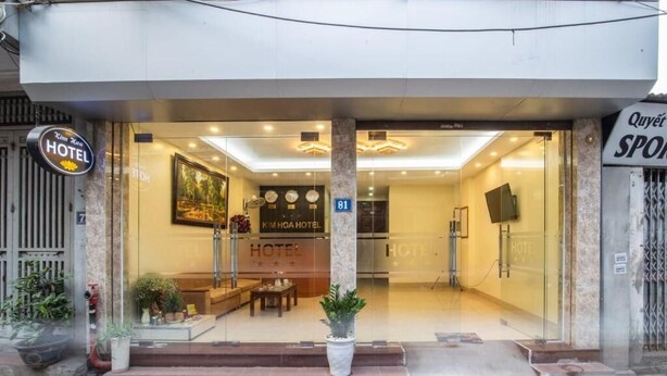 Der Eingang des Kim Hoa Hotels mit Glasfassade, einer Rezeption und einer Treppe, die nach innen führt.