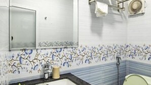 Ein Badezimmer mit Waschbecken, Spiegel, Handtuchhalter und Toilette.