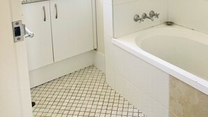 Un baño con lavamanos blanco, bañera y ducha.