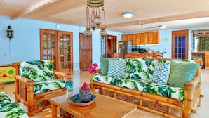 A spacious living area with a sofa set, a dining table, and a kitchen in the background. - NEW Listing - Beachfront Suite & Spacious Patio (Savaneta)