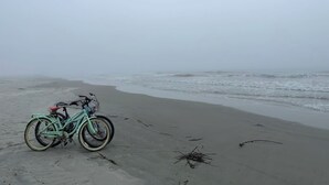 A bicycle parked on a sandy beach with the ocean in the background. - Perfect Vacation on Fripp (Fripp Island)
