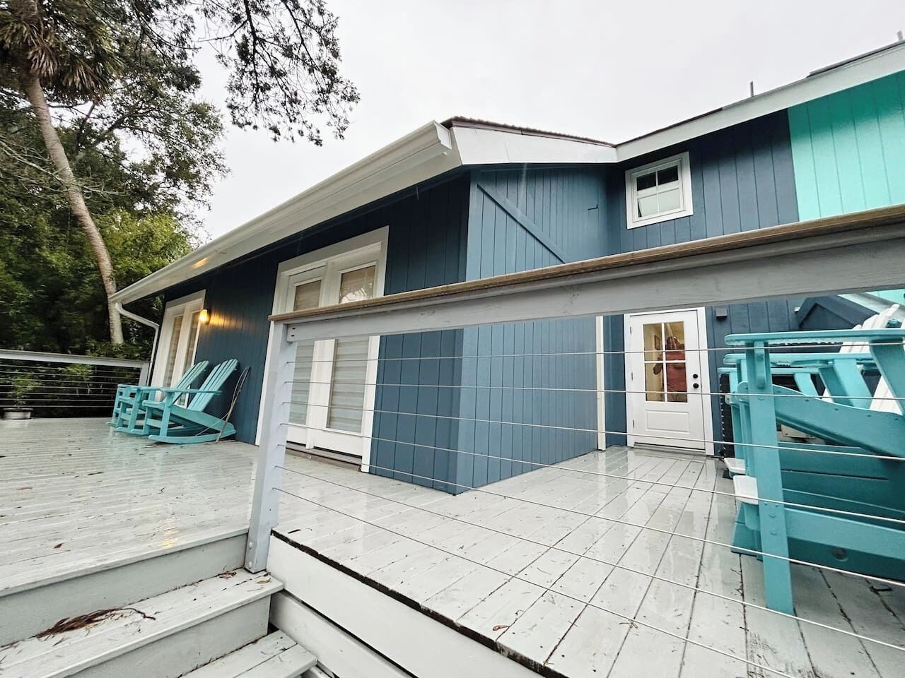 A two-story house with a covered porch, a door with glass panels, and a staircase leading to the upper level.