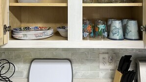 A kitchen with wooden cabinets, a white countertop, and a knife block. - B2 Boujee, a ground floor, cozy condo, just a short walk to the beach.. (Gulf Shores)