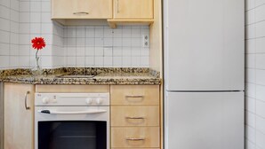 A kitchen with white cabinets, a white oven, and a white refrigerator.