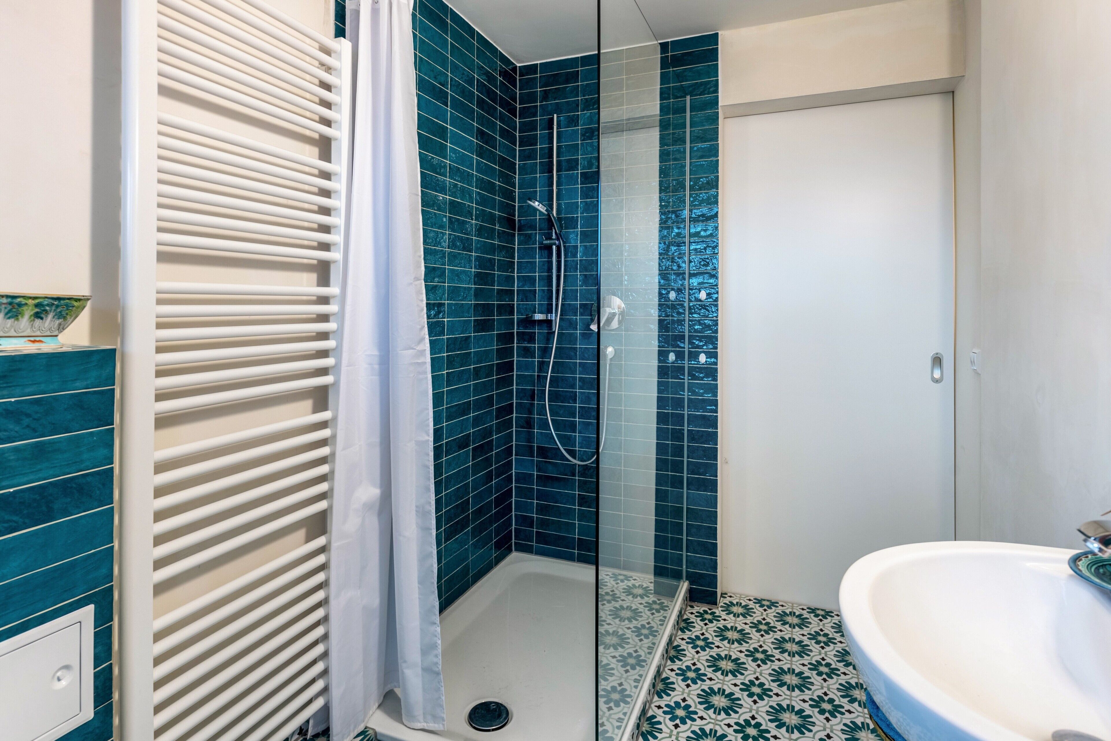 A bathroom with a shower, a sink, and a toilet.