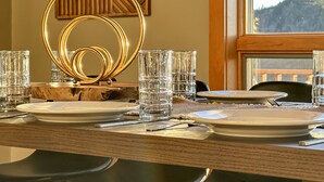 Una tavola imbandita con piatti, bicchieri e posate, e un centrotavola decorativo dorato.