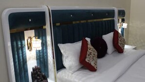 Una habitación de hotel con cama, mesita de noche y espejo.
