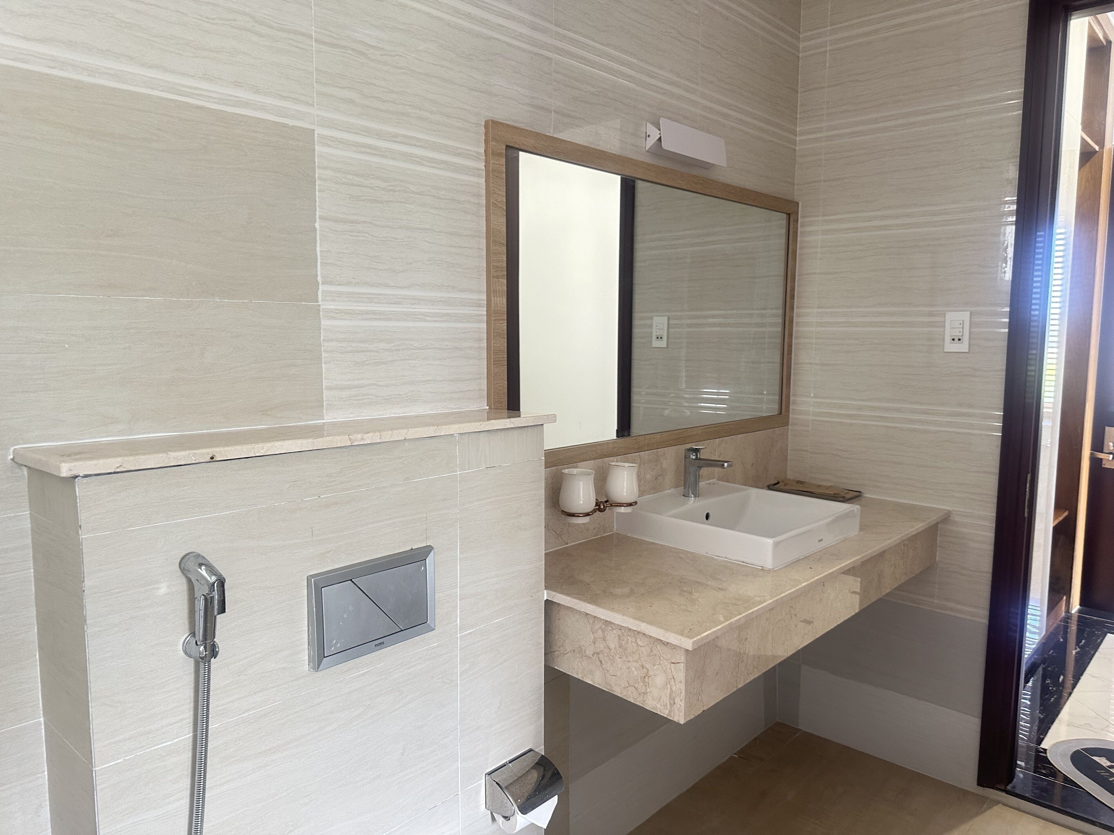 A modern bathroom with a built-in sink, a mirror, and a shower.