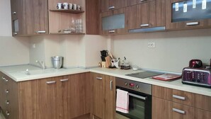A kitchen with wooden cabinets, a sink, a stove, and a toaster.