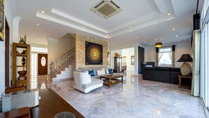 Un amplio salón con un sofá modular grande, una mesa de centro y una pared decorativa de piedra.