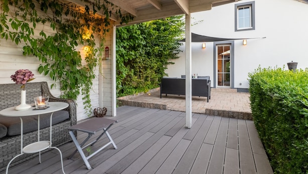 A covered patio with a seating area, a table with a candle, and a view of the house. - Charming Eifel Bakehouse with Sauna, Private Terrace & EV Charging (Feuerscheid)