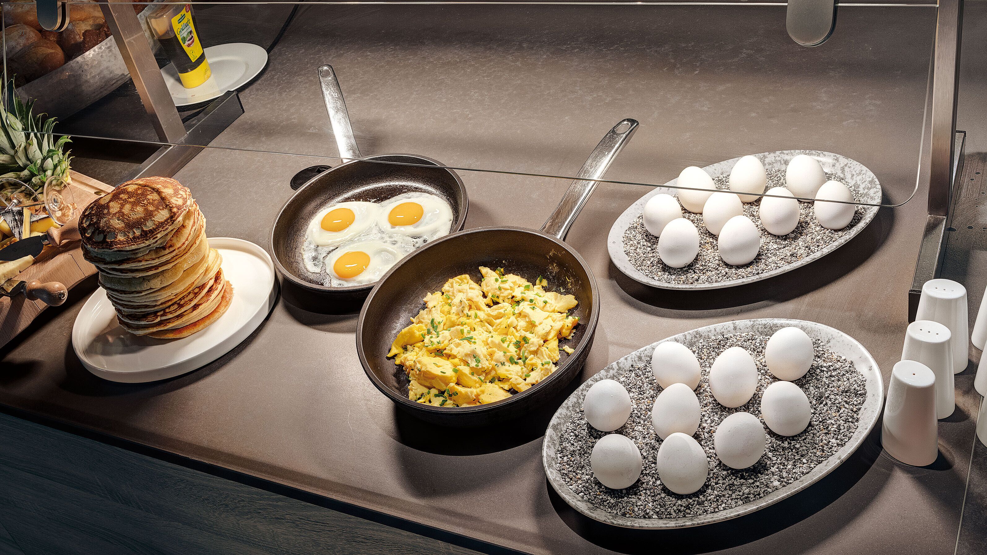 A breakfast buffet with pancakes, eggs, and scrambled eggs.