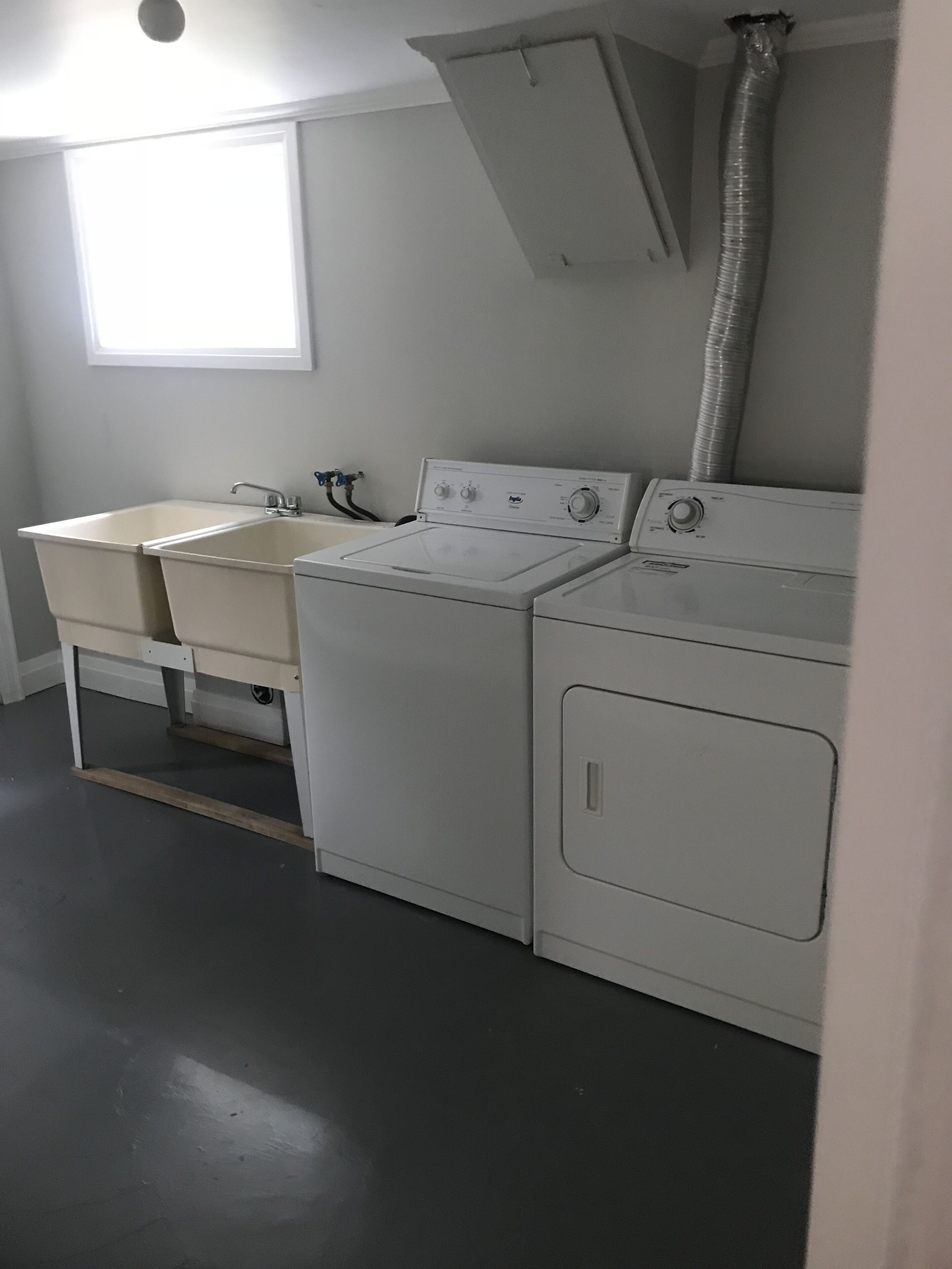 Un espace buanderie équipé d’un lave-linge, d’un sèche-linge et d’un évier.