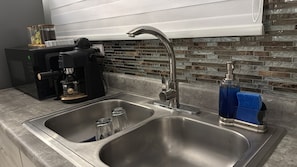 A kitchen with a double sink, a coffee maker, and a soap dispenser. - Immerse in the west coast of Puerto Rico at Islabella Guest House (Isabela)