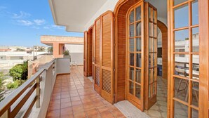 A balcony with wooden shutters, a tiled floor, and a view of the surrounding area. - Casa Marangi 250 meters from the sea (Melendugno)