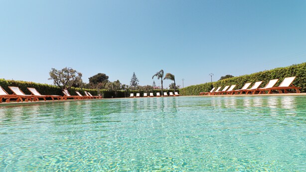 A clear swimming pool with lounge chairs on both sides. - Bungalow Fragola with Shared Pool, Wi-Fi, and Air Conditioning in Otranto (Otranto)