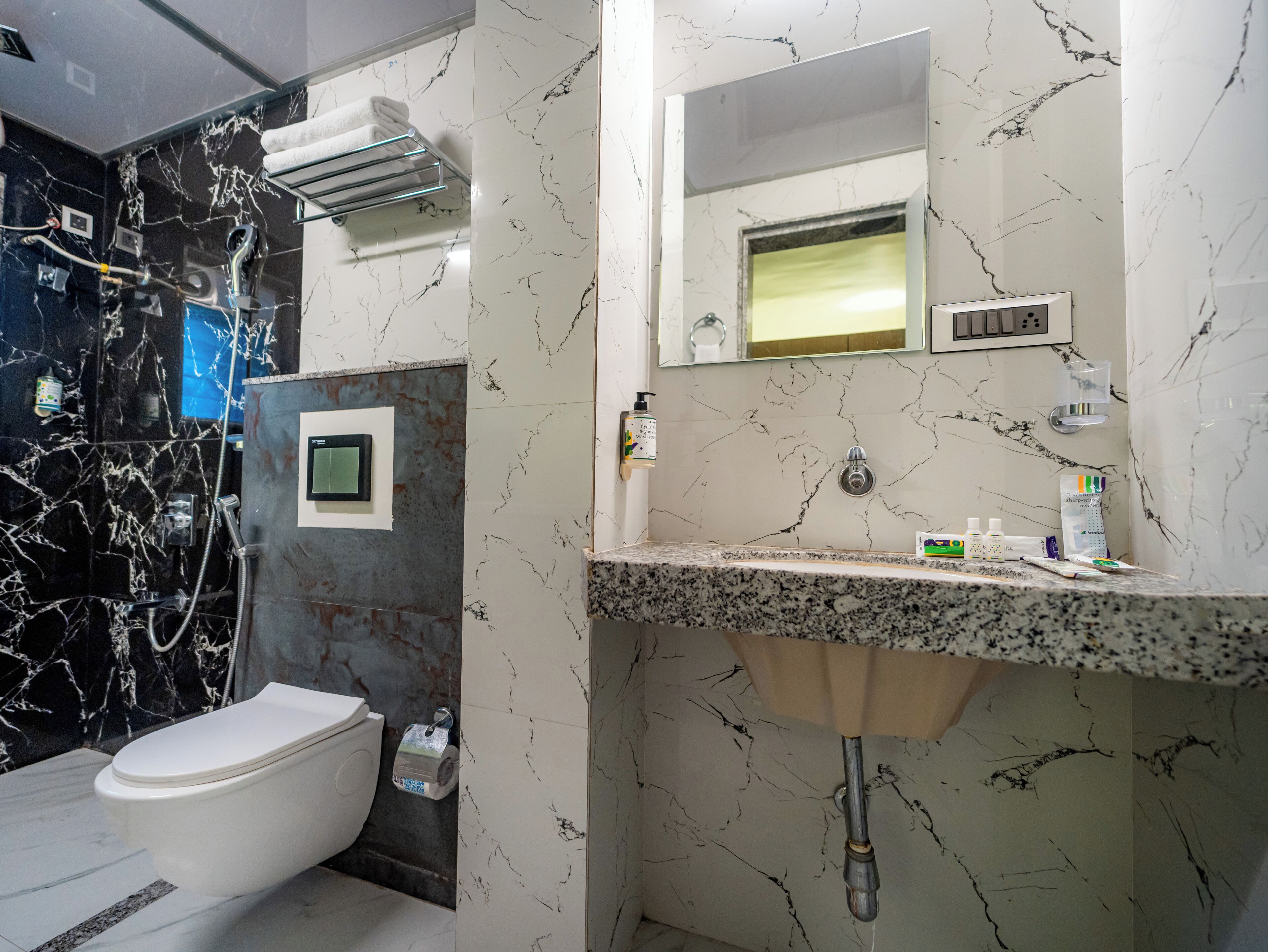 A bathroom with a toilet, a sink, a mirror, and a shower.