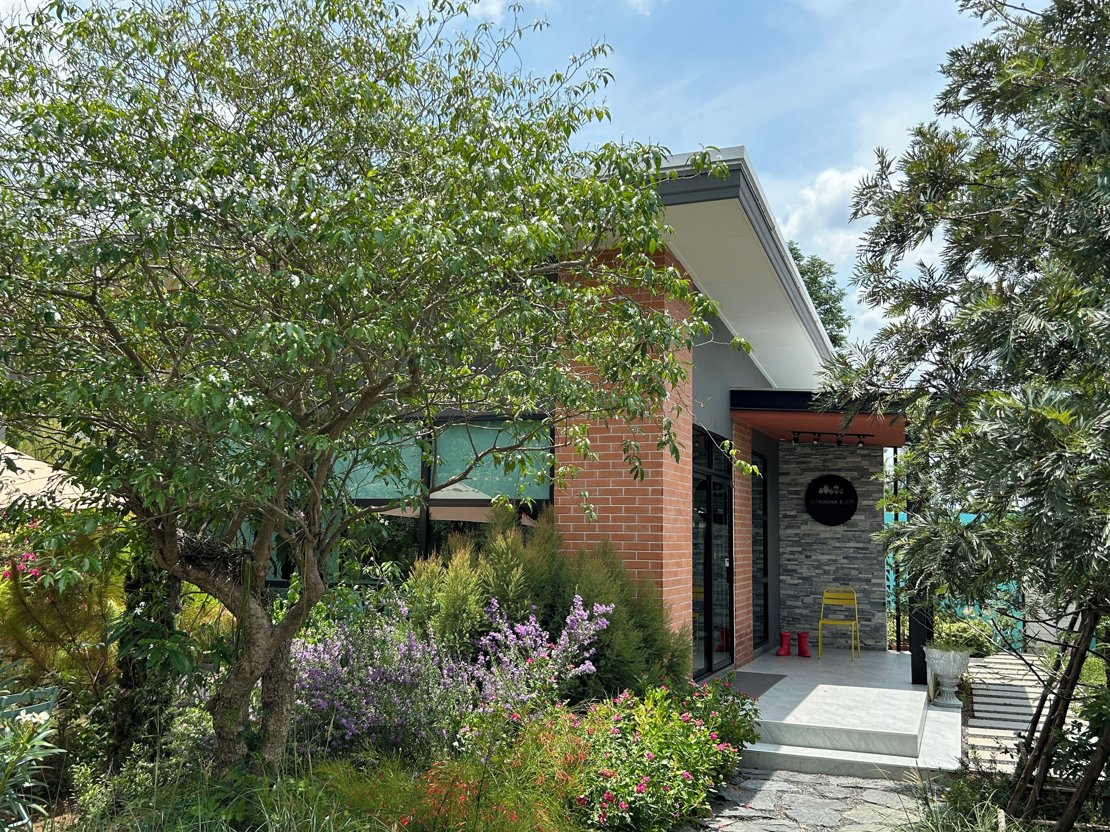 A modern building with a brick facade, a stone accent wall, and a glass door entrance.