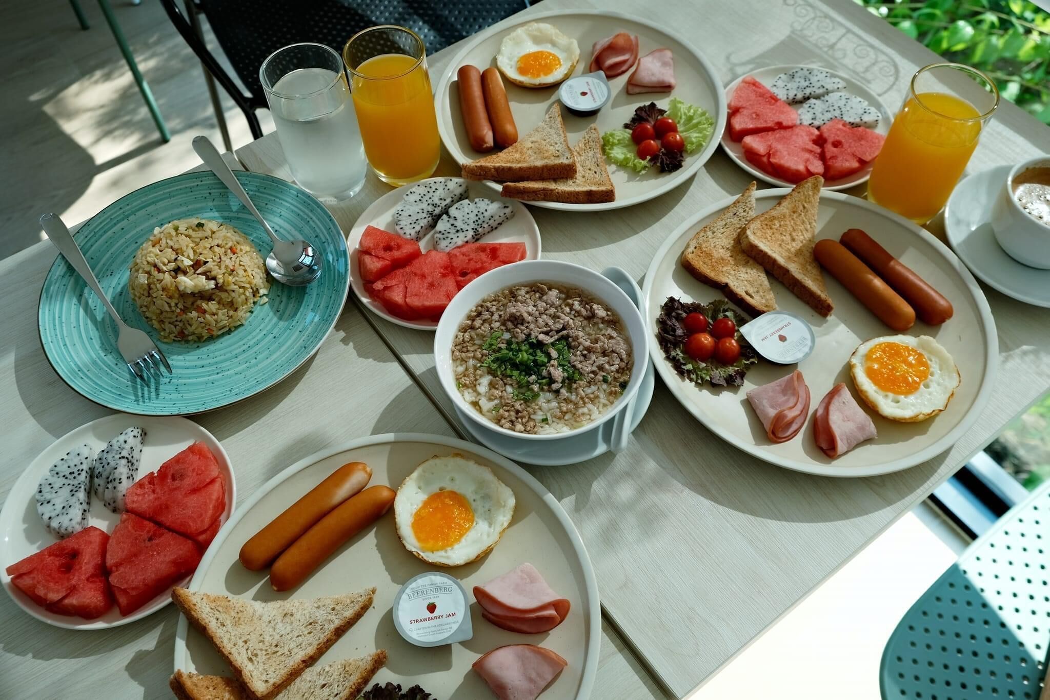 A table with breakfast items including toast, eggs, sausages, and fruit.