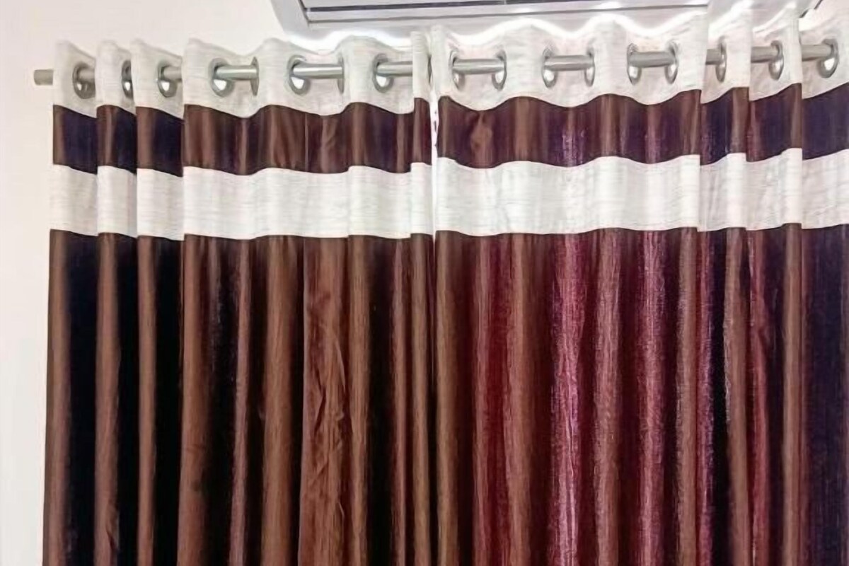 Cortina com padrão de listras verticais e borda branca.