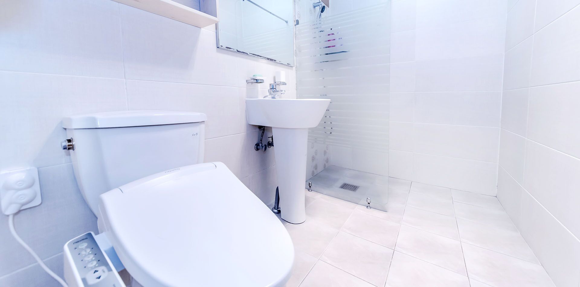 A modern bathroom with a toilet, sink, and shower.