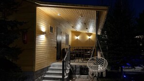 A wooden cabin with a covered porch, a fire extinguisher, and a hanging chair. - Bellissimo Garden Villa (Tsaghkadzor)