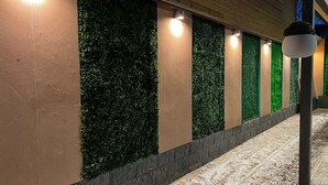 Un couloir agrémenté de jardins verticaux et doté d’un éclairage encastré.