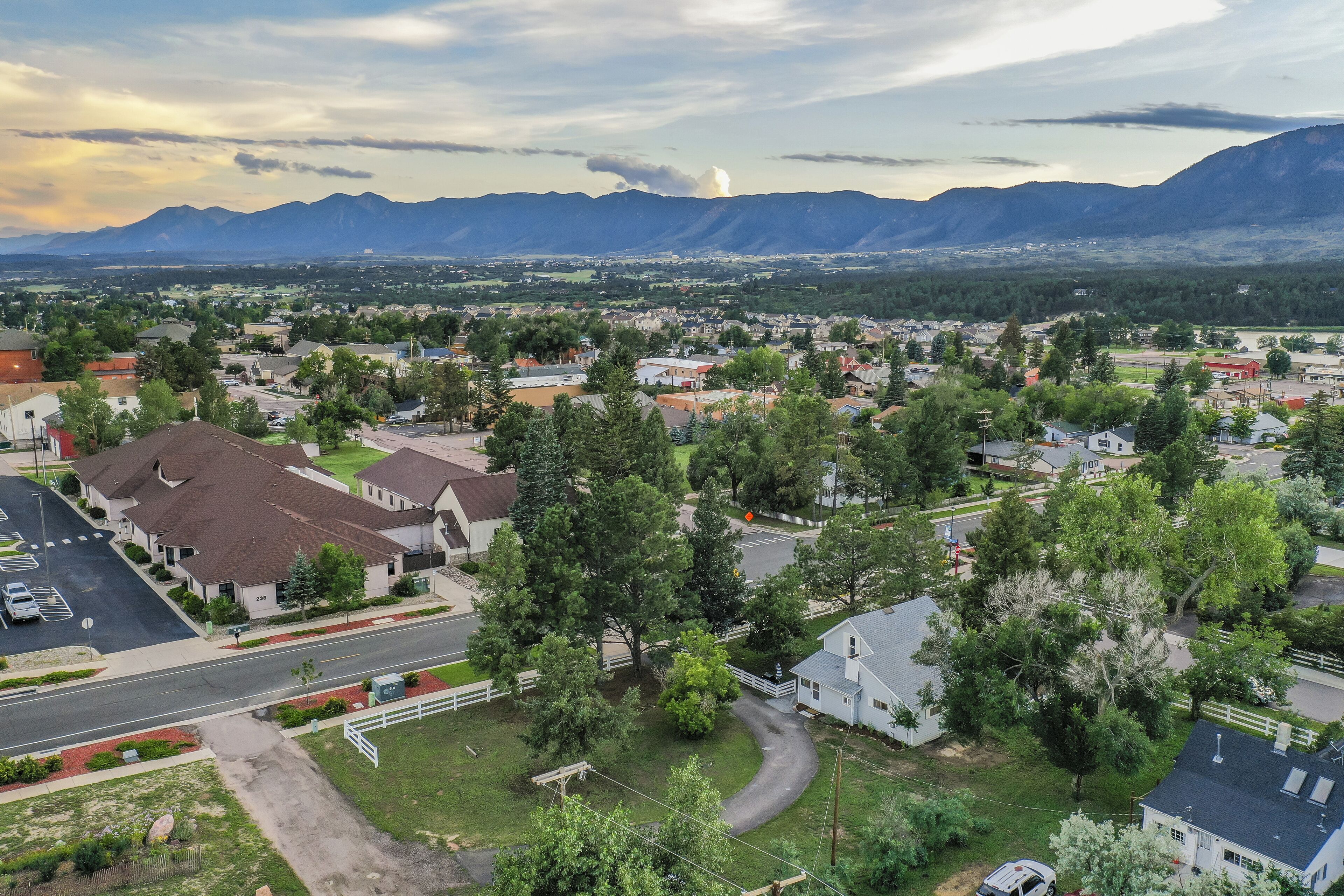 A residential area with houses, roads, and mountains in the background.