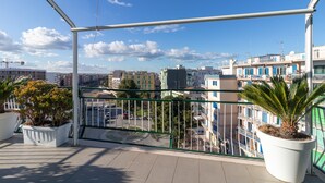 Un balcó amb vista a un paisatge urbà, amb edificis i una grua de construcció.