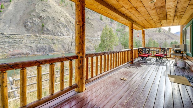 A wooden deck with a view of a river and hills.