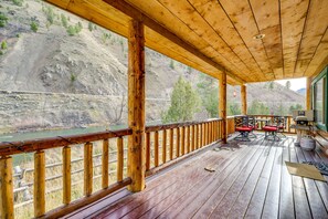 A wooden deck with a view of a river and hills. - Pet-Friendly Idaho Home on the Salmon River! (Salmon)