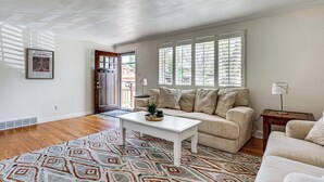 Un salon avec un canapé blanc, une table basse et un tapis à motifs.